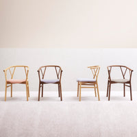 "Set of four stylish chairs in pastel and earthy tones, featuring contrasting wood finishes and minimalist design."
