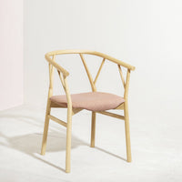 Light wood chair with a minimalist design and soft pink fabric cushion, featuring clean lines and a natural finish.