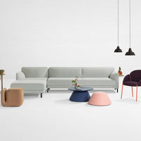 Light gray sectional sofa, navy and pink accent tables, dark purple chair, modern design with subtle patterns.