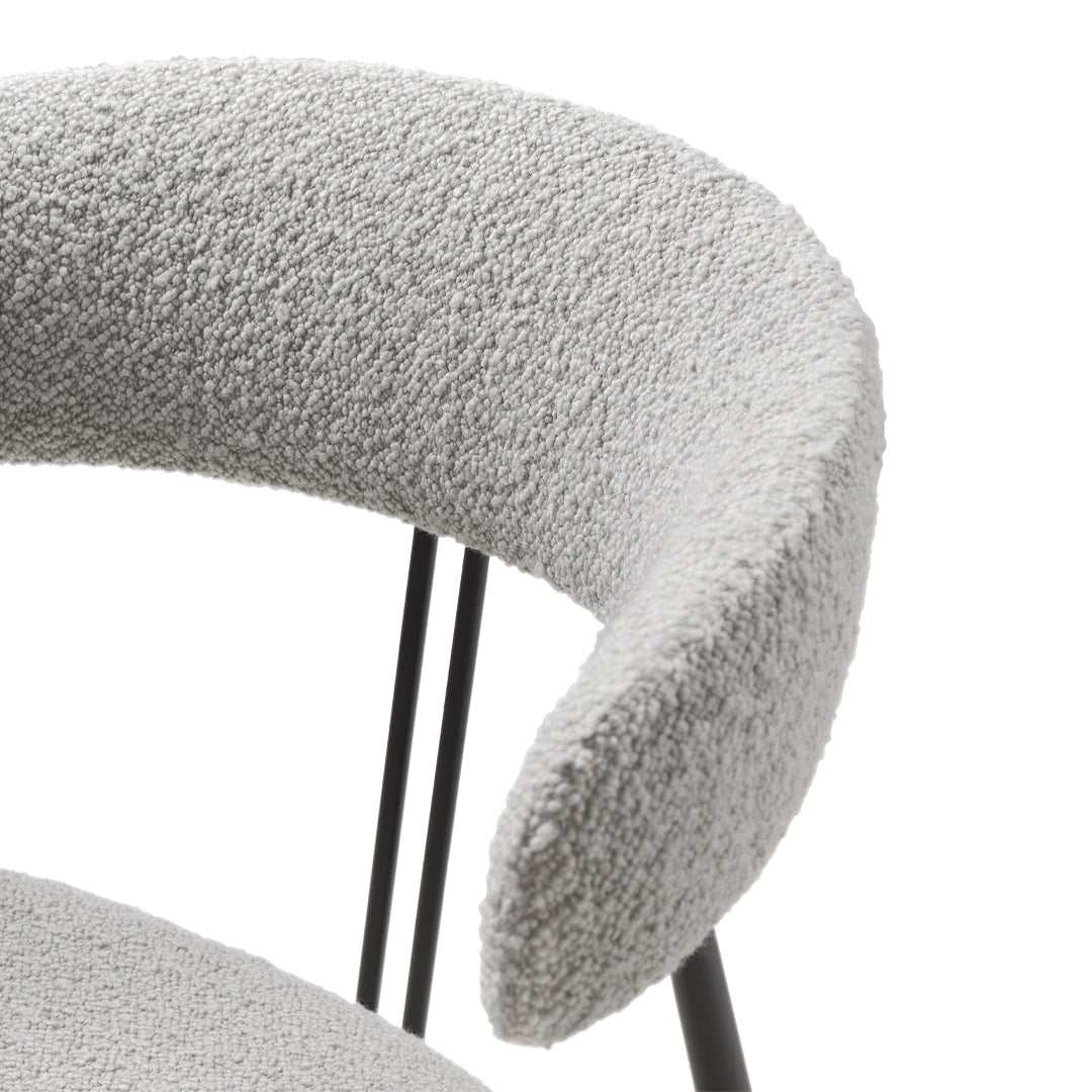 Soft gray textured fabric with curved armrest, complemented by sleek black metal legs. Modern and stylish design.