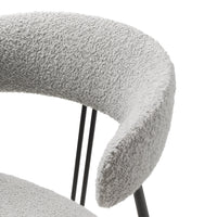 Soft gray textured fabric with curved armrest, complemented by sleek black metal legs. Modern and stylish design.