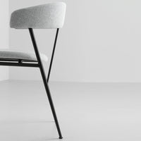 Gray upholstered chair with a minimalist design and sleek black legs, set against a light gray background.