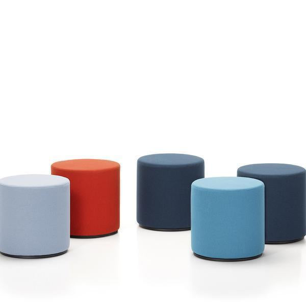 Colorful, round ottomans in light blue, dark blue, red, and light gray, featuring smooth, solid patterns.