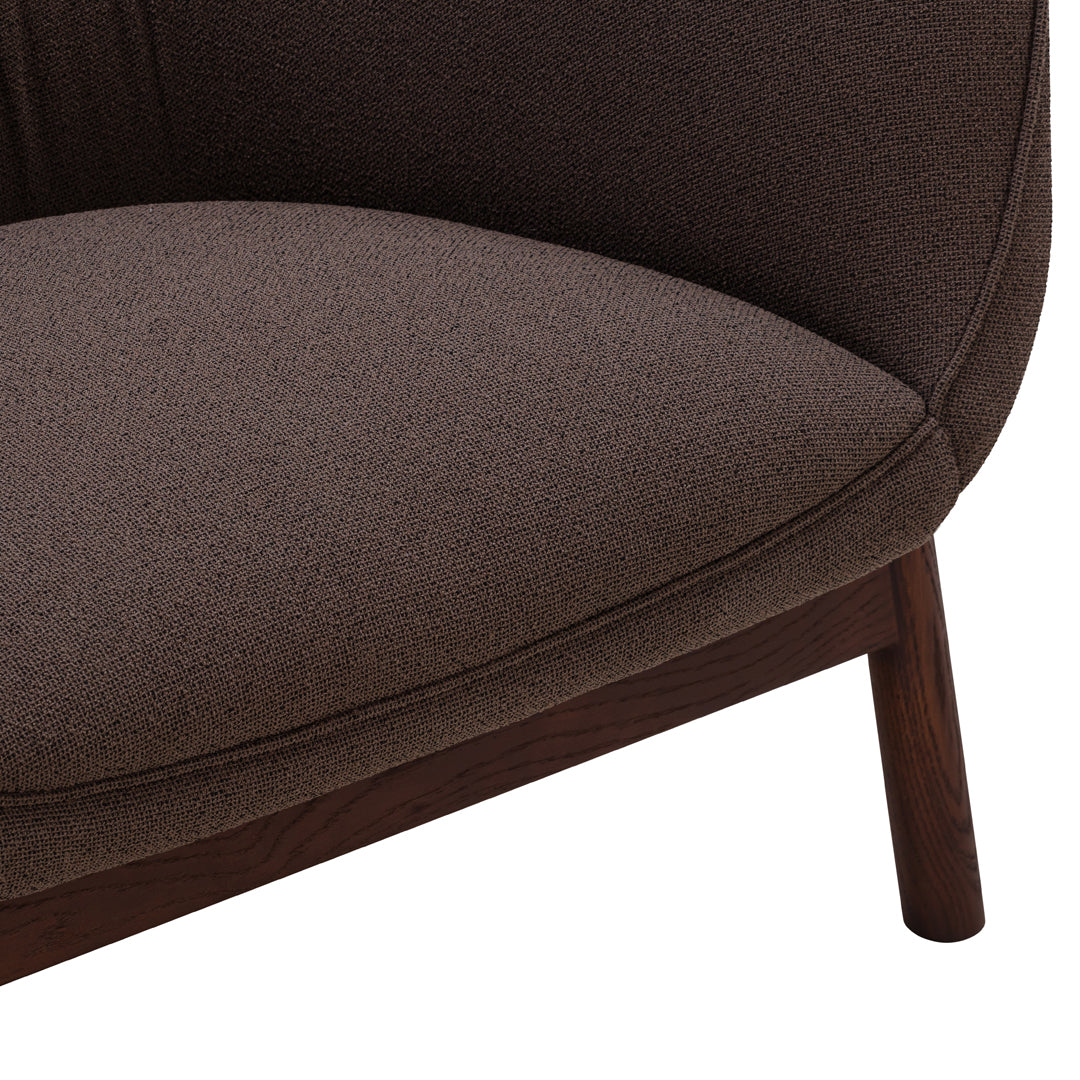 "Brown textured upholstery on a modern chair, showcasing smooth curves and a rich, earthy tone."