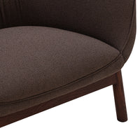 "Brown textured upholstery on a modern chair, showcasing smooth curves and a rich, earthy tone."