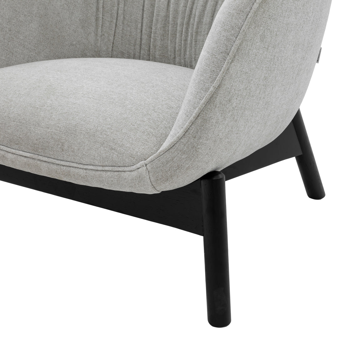 Gray upholstered chair with smooth fabric and black wooden legs, featuring subtle vertical tufting for added texture.