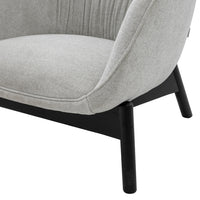 Gray upholstered chair with smooth fabric and black wooden legs, featuring subtle vertical tufting for added texture.
