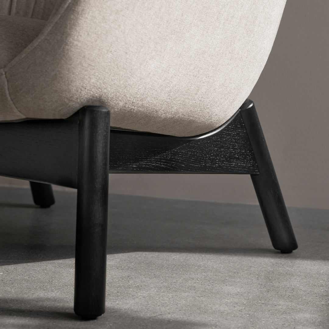 Light grey upholstered chair with a sleek black wooden base, showcasing a minimalist and modern design.