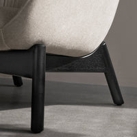 Light grey upholstered chair with a sleek black wooden base, showcasing a minimalist and modern design.