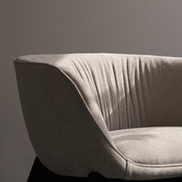 Light gray upholstered chair with subtle vertical pleats, featuring a modern, minimalist design.
