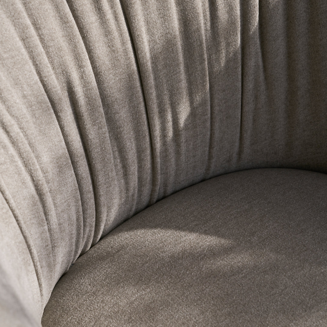 Soft beige upholstery with elegant vertical pleats and a smooth, rounded cushion in subtle, neutral tones.