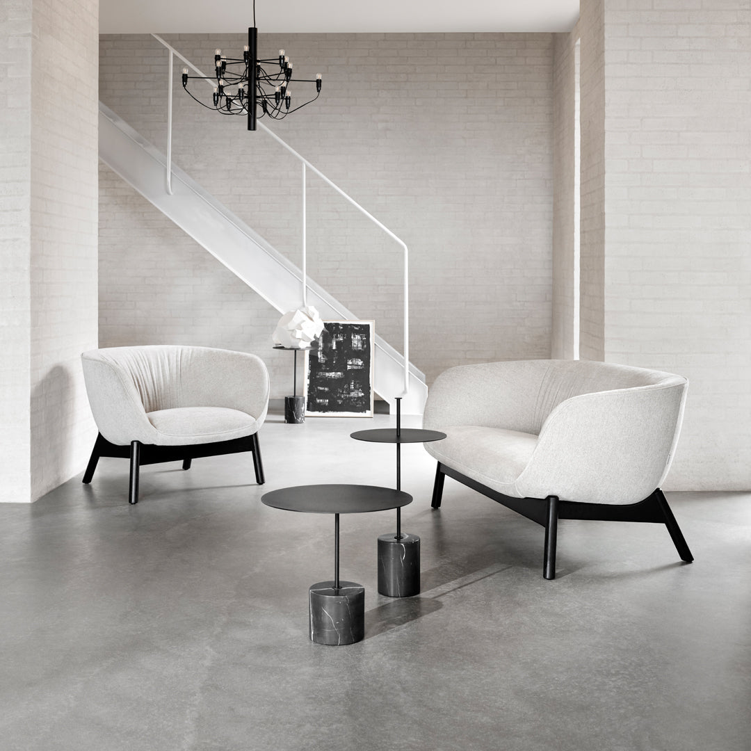 Stylish black and white seating with smooth fabric and sleek lines, set in a minimalist modern space.