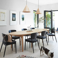 "Light wood dining table with black chairs, minimalist decor, and neutral tones complemented by natural wood accents."