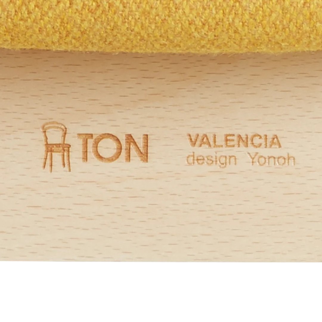 Close-up of textured yellow fabric on a wooden chair, showcasing a vibrant color and subtle patterns.