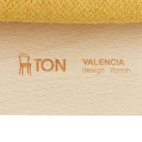 Close-up of textured yellow fabric on a wooden chair, showcasing a vibrant color and subtle patterns.