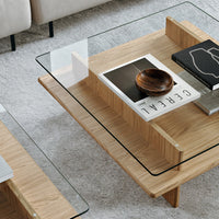 Wooden coffee table with a light oak finish and a clear glass top, featuring sleek, modern lines and minimalistic design.