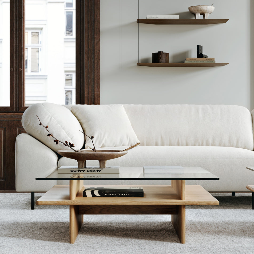 Modern white couch with soft texture, paired with a minimalist wooden coffee table and light gray area rug.