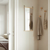 Elegant gold-framed mirror with neutral wall tones and soft textures, enhancing a modern, minimalist decor.