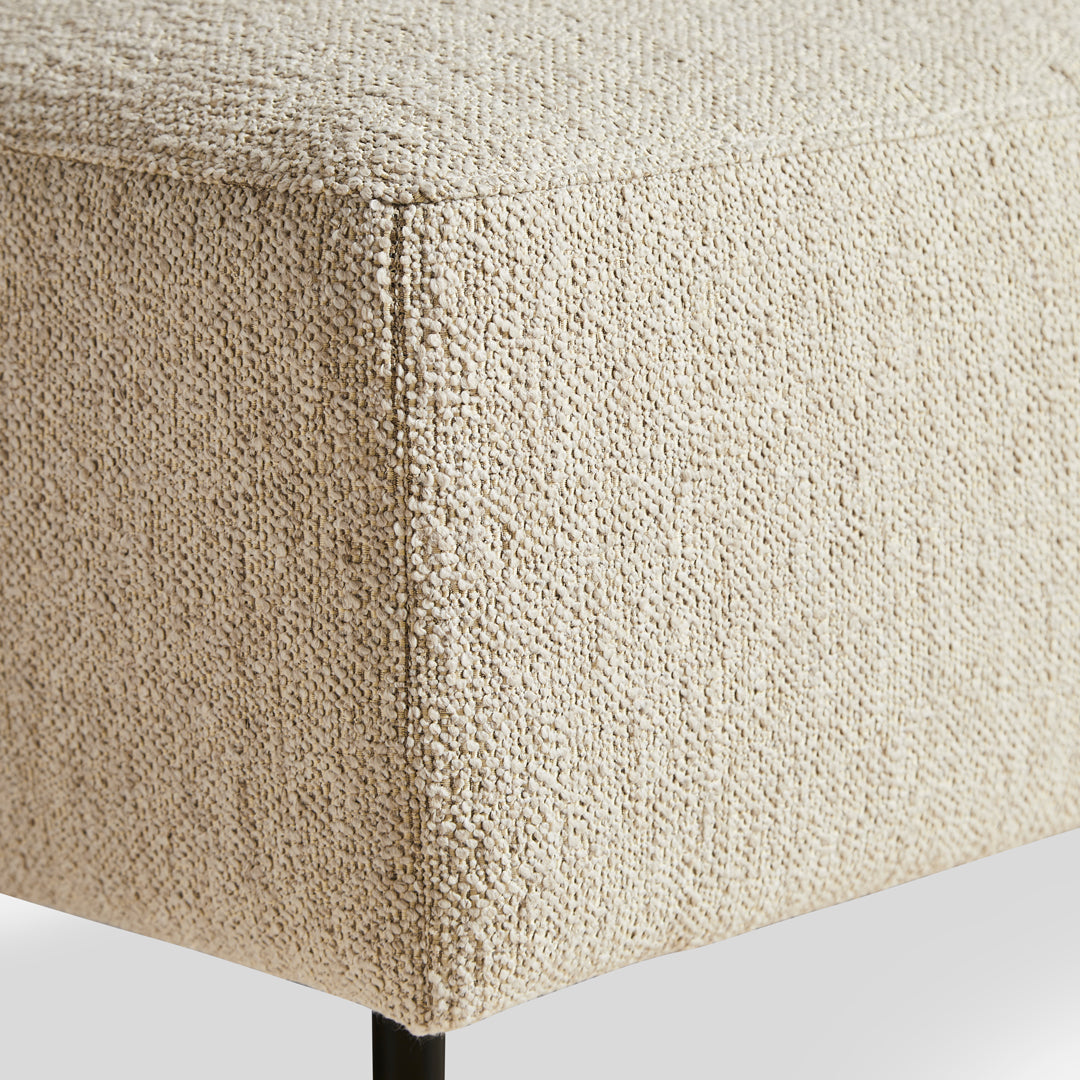 Textured beige fabric with a natural woven pattern on a modern ottoman. Stylish and versatile for any decor.