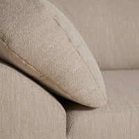 Beige textured fabric close-up with soft, subtle patterns on a sofa cushion.