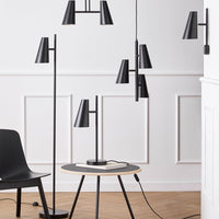 Black modern lamp set with sleek lines, geometric shapes, and minimalist design on a light wood floor.