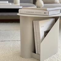 Light beige side table featuring a minimalistic design with smooth surfaces and a sleek geometric pattern.