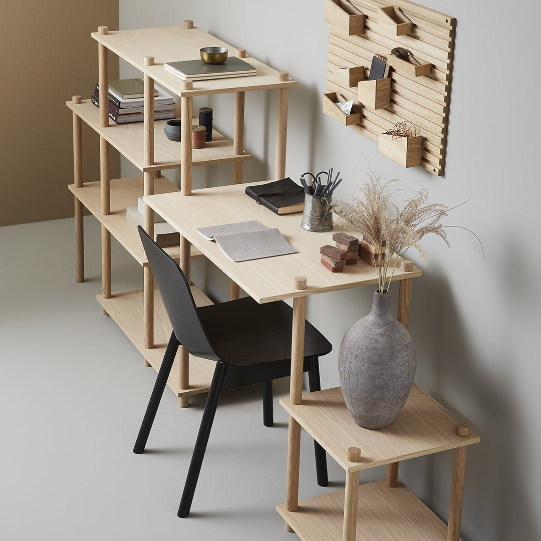 Light wood shelves with a minimalist design, paired with a black chair and soft beige wall for a modern aesthetic.