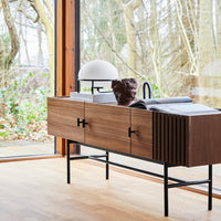 Modern wooden sideboard in rich walnut finish with sleek black metal frame and subtle ribbed pattern.