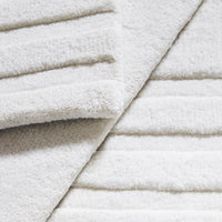 Soft white textured fabric with subtle raised stripe pattern, perfect for a cozy home ambiance.