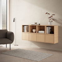 Light wood storage unit with vertical ribbed pattern, complemented by a neutral gray rug and soft beige walls.
