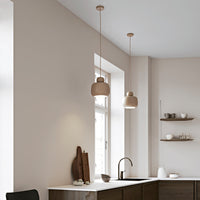 Two beige pendant lights hang from a light gray ceiling in a modern kitchen with minimalist decor.