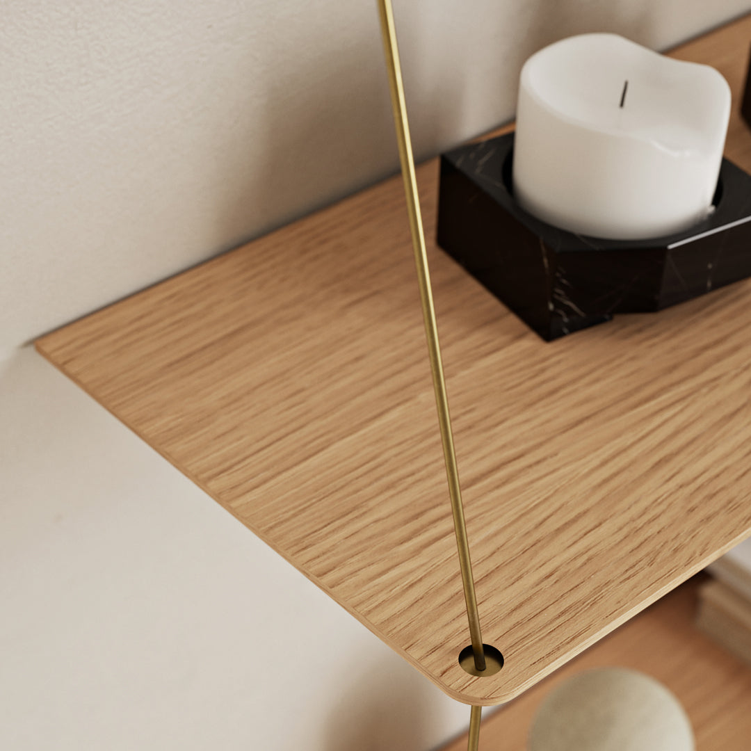 Natural oak wood shelf with smooth grain, complemented by a sleek gold accent and minimalist black and white decor.