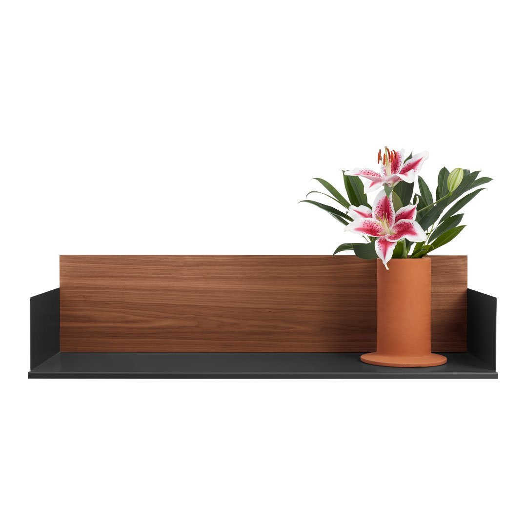 Modern shelf with a dark wood finish and a sleek black base, featuring a terracotta vase with pink lilies.