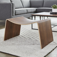 "Curved wood coffee table in dark walnut finish, set on a textured white rug, with a modern gray sofa in the background."