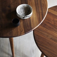 "Elegant wood grain tables in rich brown tones, featuring contrasting black and white decorative bowls."