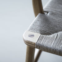 Gray woven seat with natural wood accents, showcasing a modern minimalistic design. Perfect for contemporary decor.