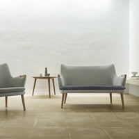 Gray and light blue upholstered sofa set with wooden legs on a neutral-toned tiled floor in a minimalist space.