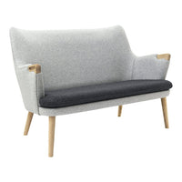 Gray and black two-tone upholstered loveseat with light wood legs, featuring a smooth, textured finish.