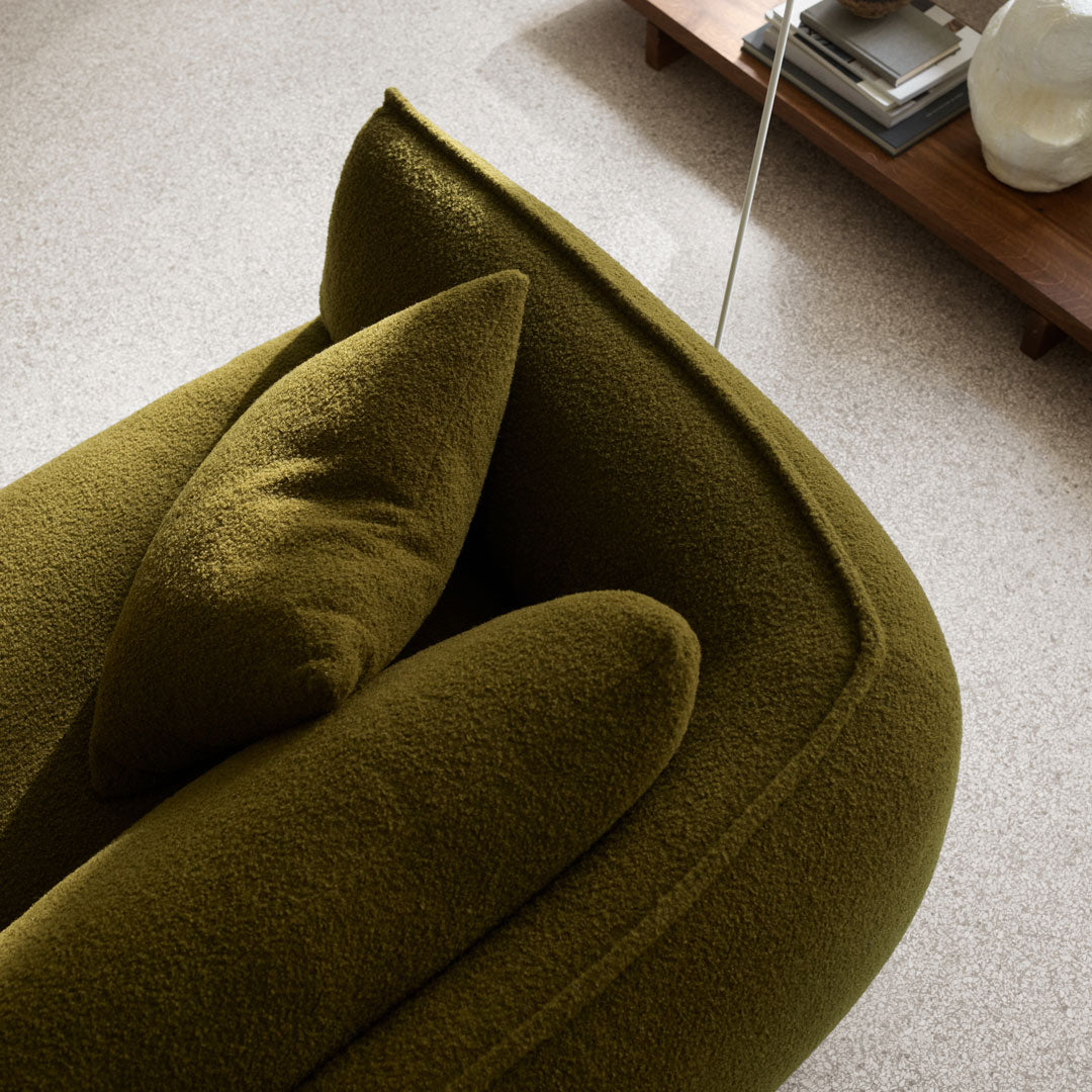 Olive green upholstered sofa cushions with textured, plush fabric, showcasing a modern, cozy design.