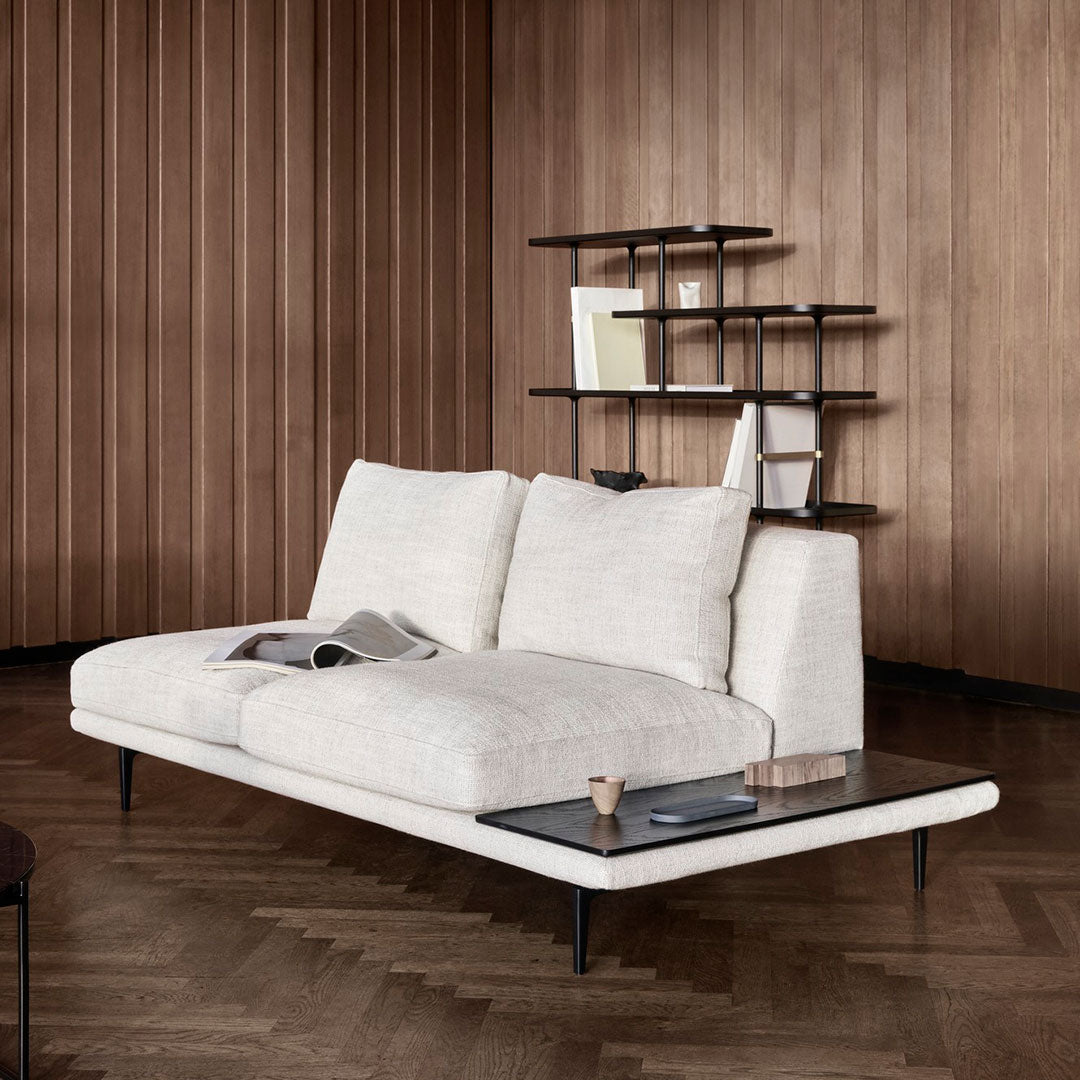 Modern light cream sofa with textured cushions, sleek black legs, and a glass top coffee table against a wooden backdrop.