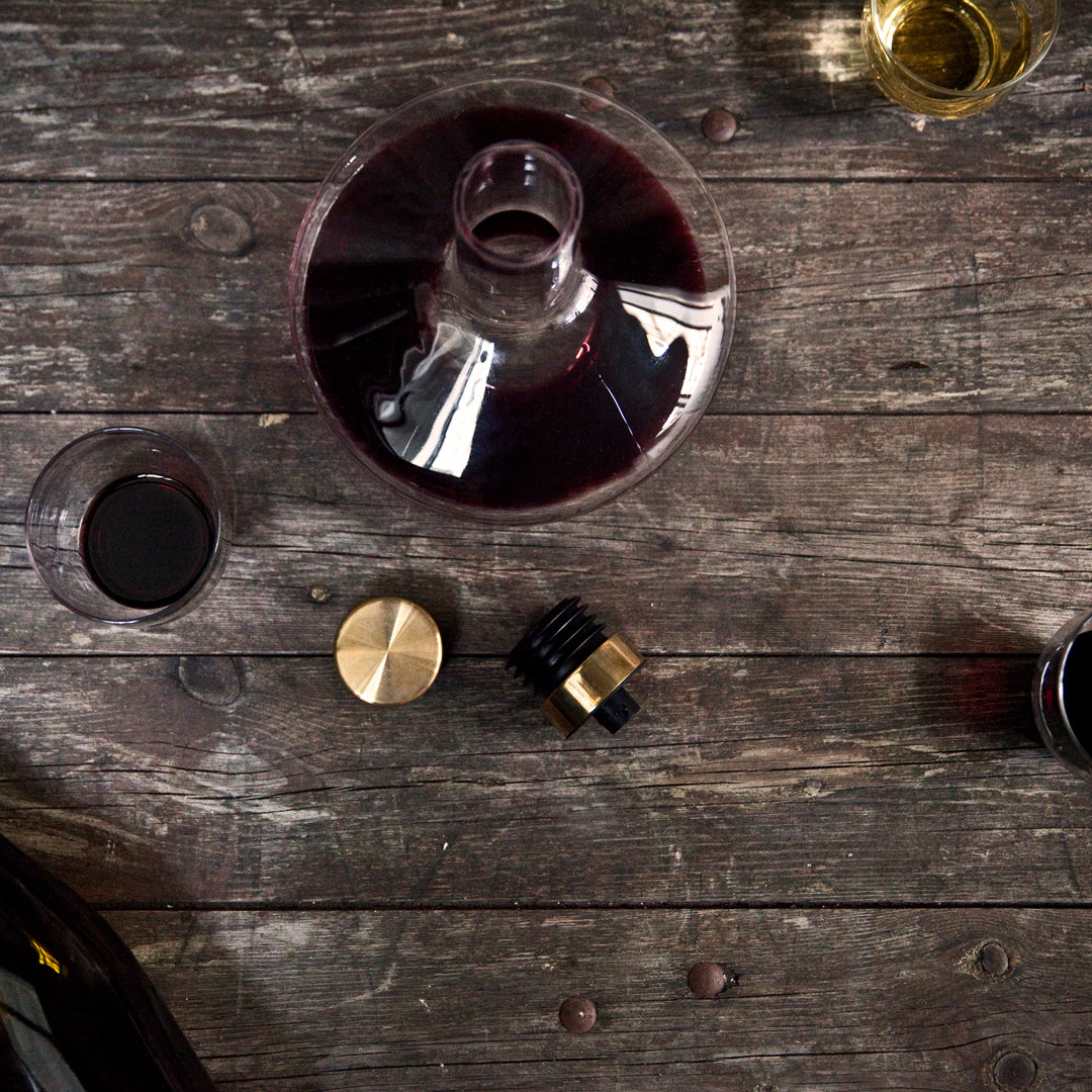 "Elegant glass decanter with deep red wine, gold accents, and rich wooden background textures."
