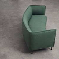 Curved green sofa with a textured fabric and minimalist design, perfect for modern living spaces.