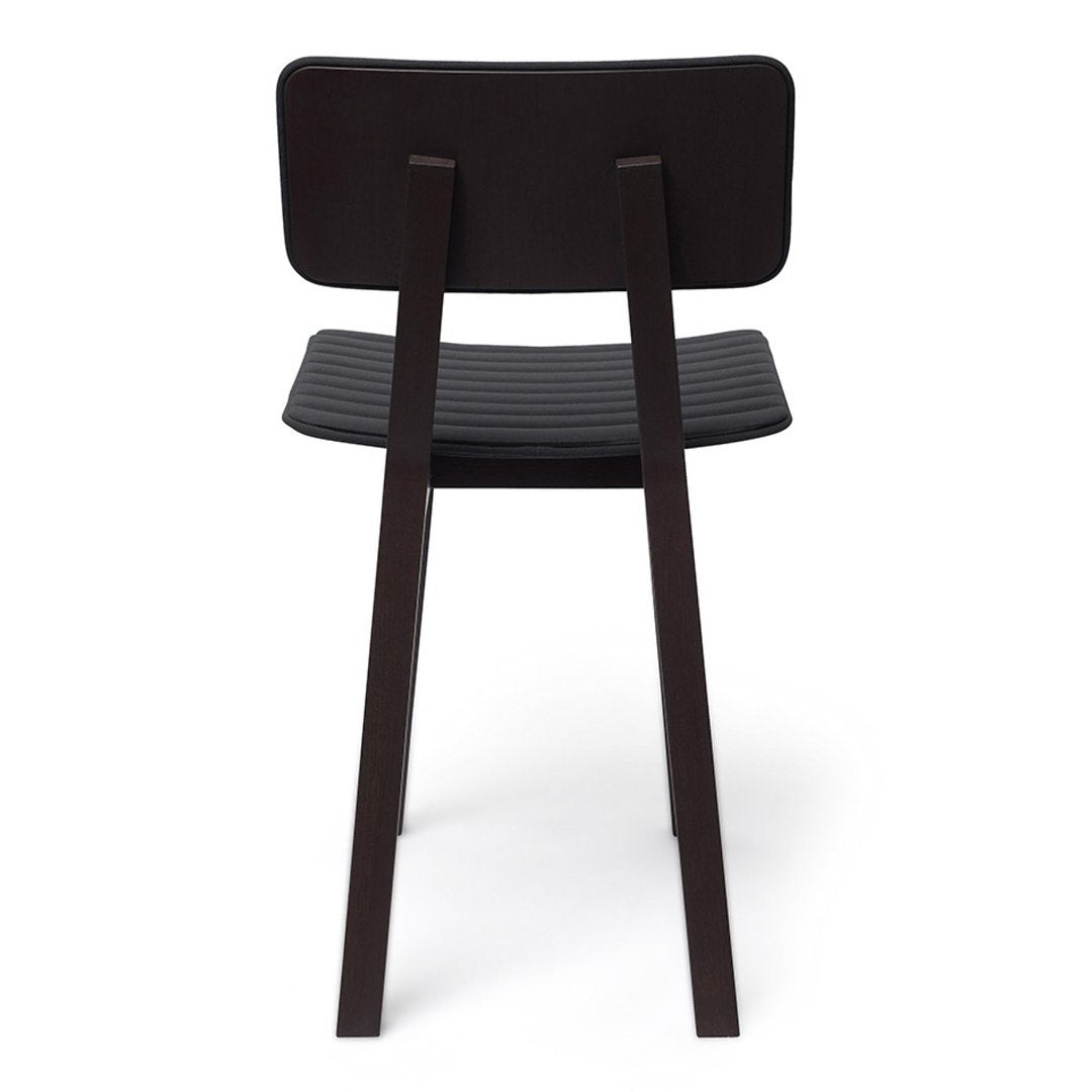 Back view of a sleek black wooden chair with a ribbed seat and minimalist design. Ideal for modern decor.