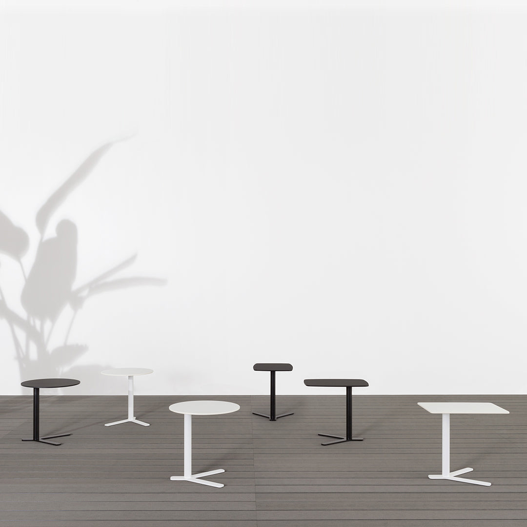 Elegant black and white tables with sleek lines on a modern wooden floor, creating a minimalist aesthetic.