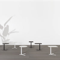Elegant black and white tables with sleek lines on a modern wooden floor, creating a minimalist aesthetic.