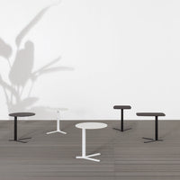 Minimalist tables in black and white, featuring sleek designs and geometric shapes on a wooden floor.