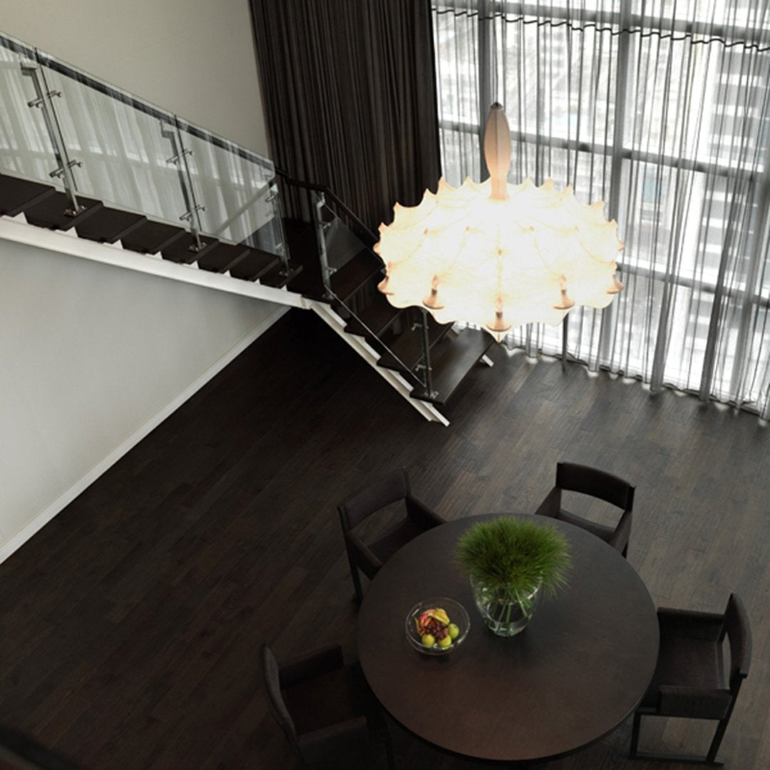 Chic white chandelier above a dark wood table, contrasted with soft cream curtains and modern black chairs.