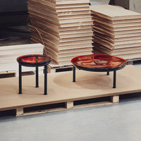 Set of two modern coffee tables featuring vibrant red and orange circular tops with black metal legs. 