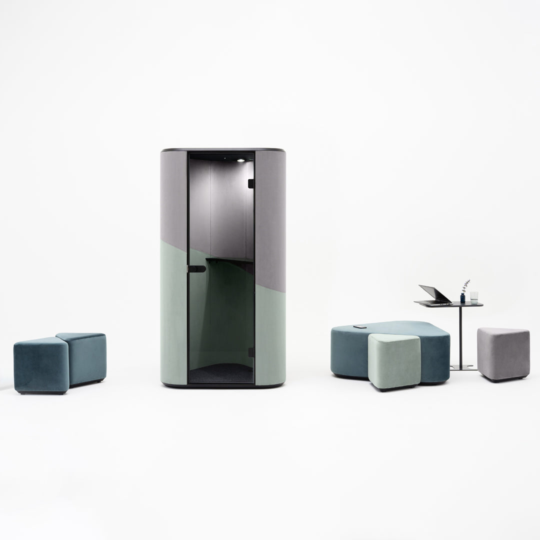Modern privacy booth in grey and green tones, complemented by teal and grey cube seating and a sleek table.