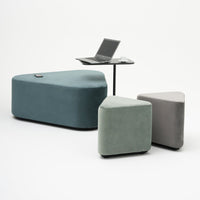"Set of three geometric-shaped cushions in teal, sage green, and gray fabric, with a sleek tabletop."